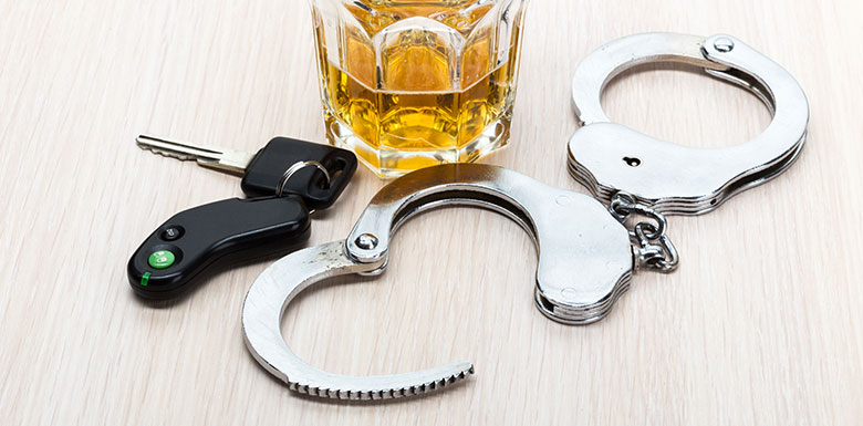 Glass-of-Booze-Surrounded-by-Handcuffs-and-Car-Keys-Belonging-to-Someone-who-Got-a-DUI-in-Detroit-on-a-Holiday