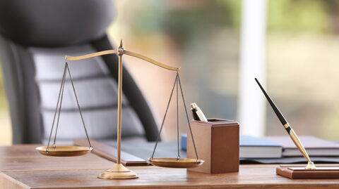 Attorney's desk with gold pen and scales