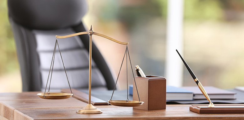 Attorney's desk with gold pen and scales