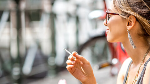 Smiling woman smoking marijuana