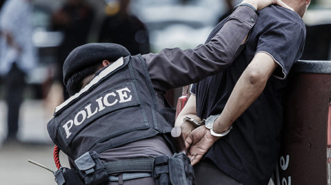 Police officer handcuffing man